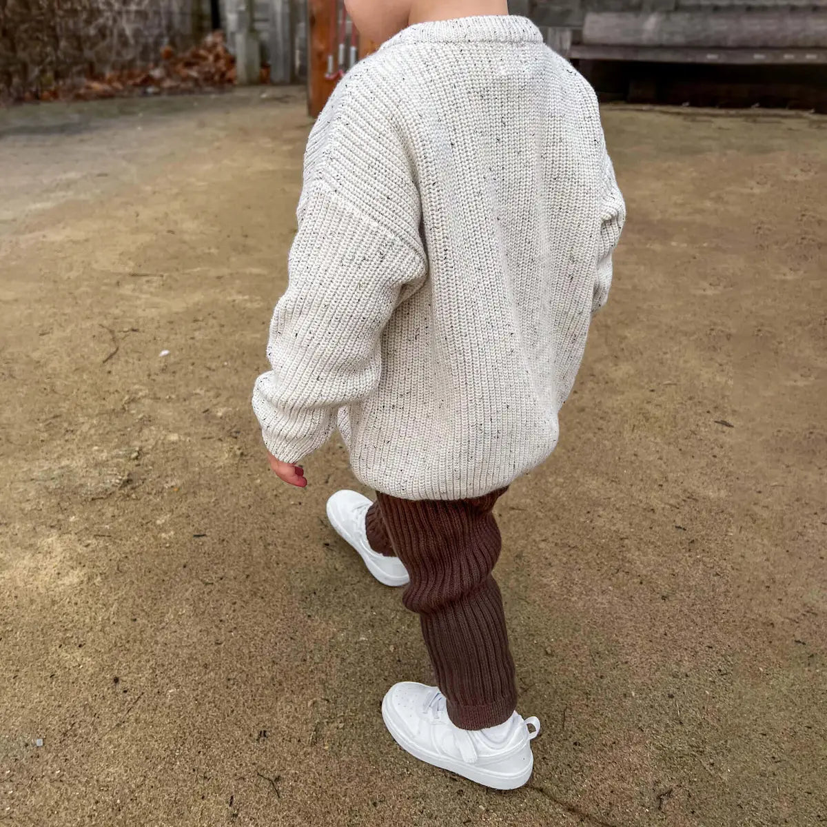 toddler wearing mix & match items including oversized chunky knit jumper in frosty speckle and chunky knit leggings in cocoa, cozy and stylish for a day of play