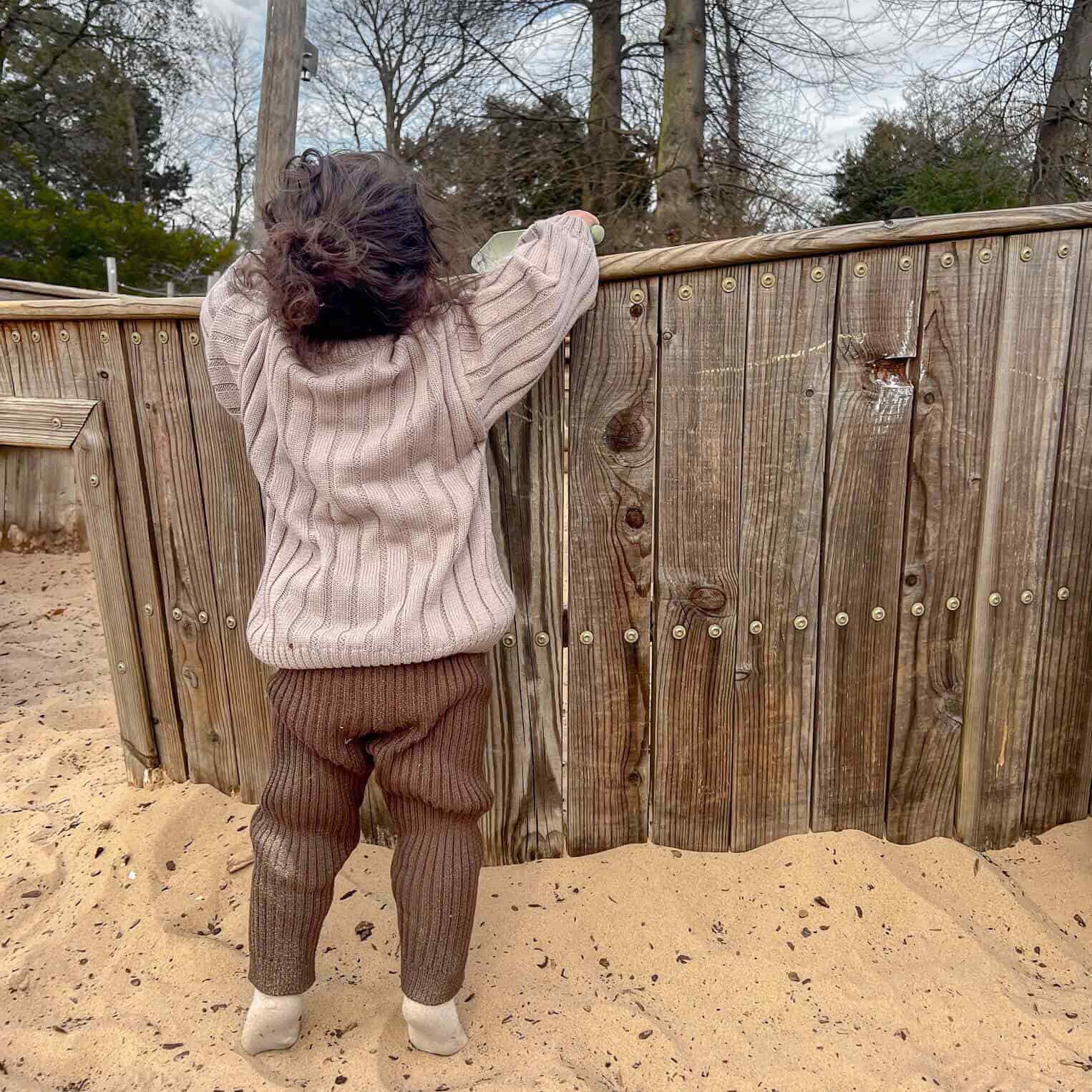 toddler wearing wide rib knit set jumper with lmix & match leggings in cocoa, playing in the sandpit